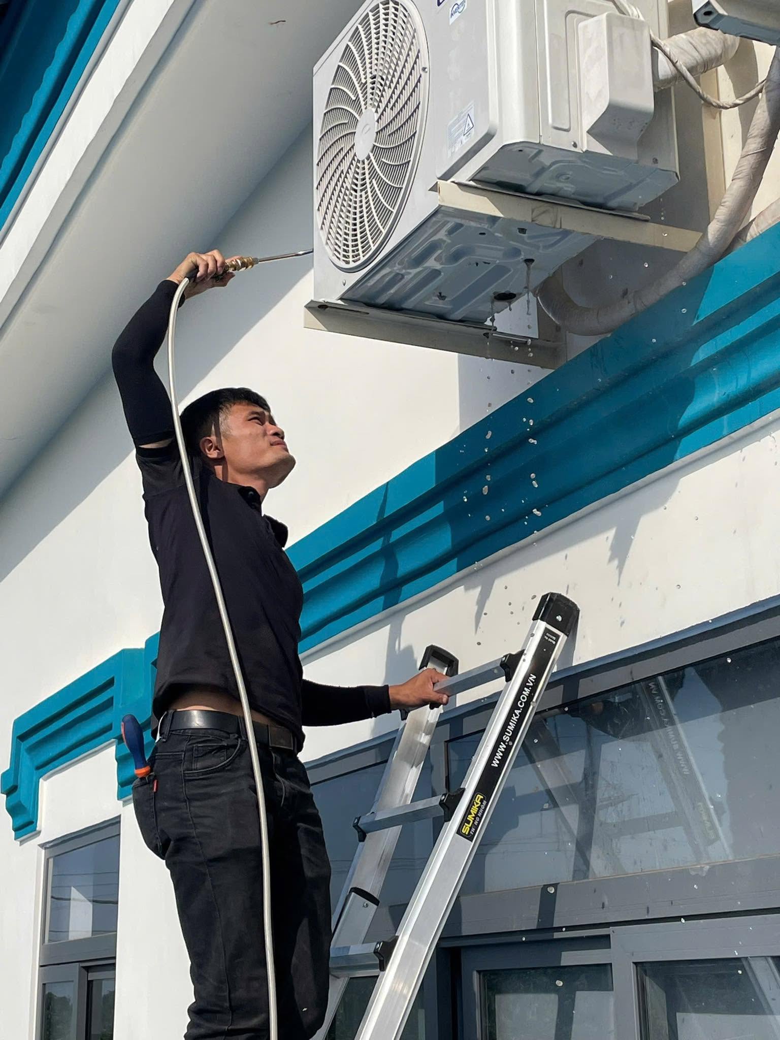 Kỹ thuật viên xịt rửa vệ sinh dàn nóng máy lạnh