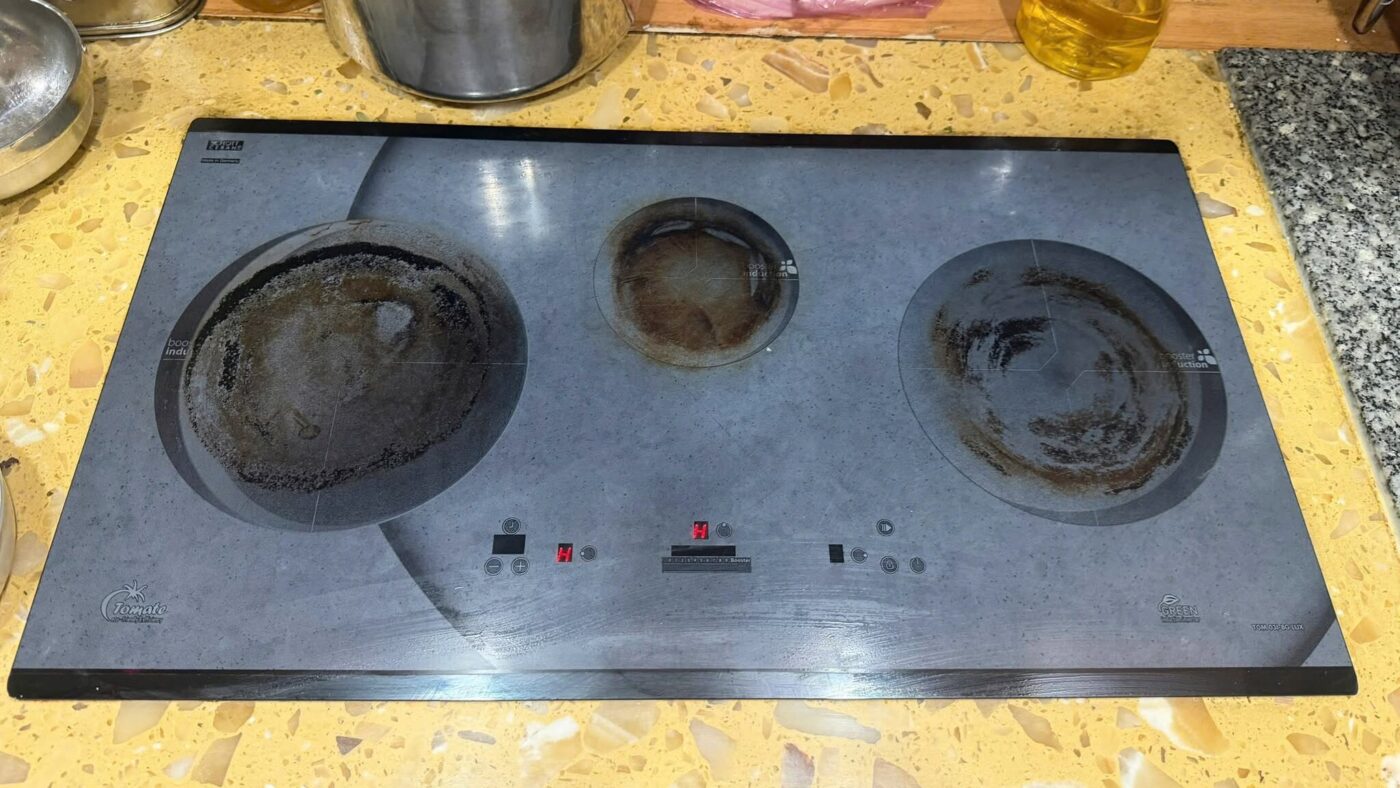 Mặt kính bếp từ 3 vùng nấu bám vết cháy cần vệ sinh
