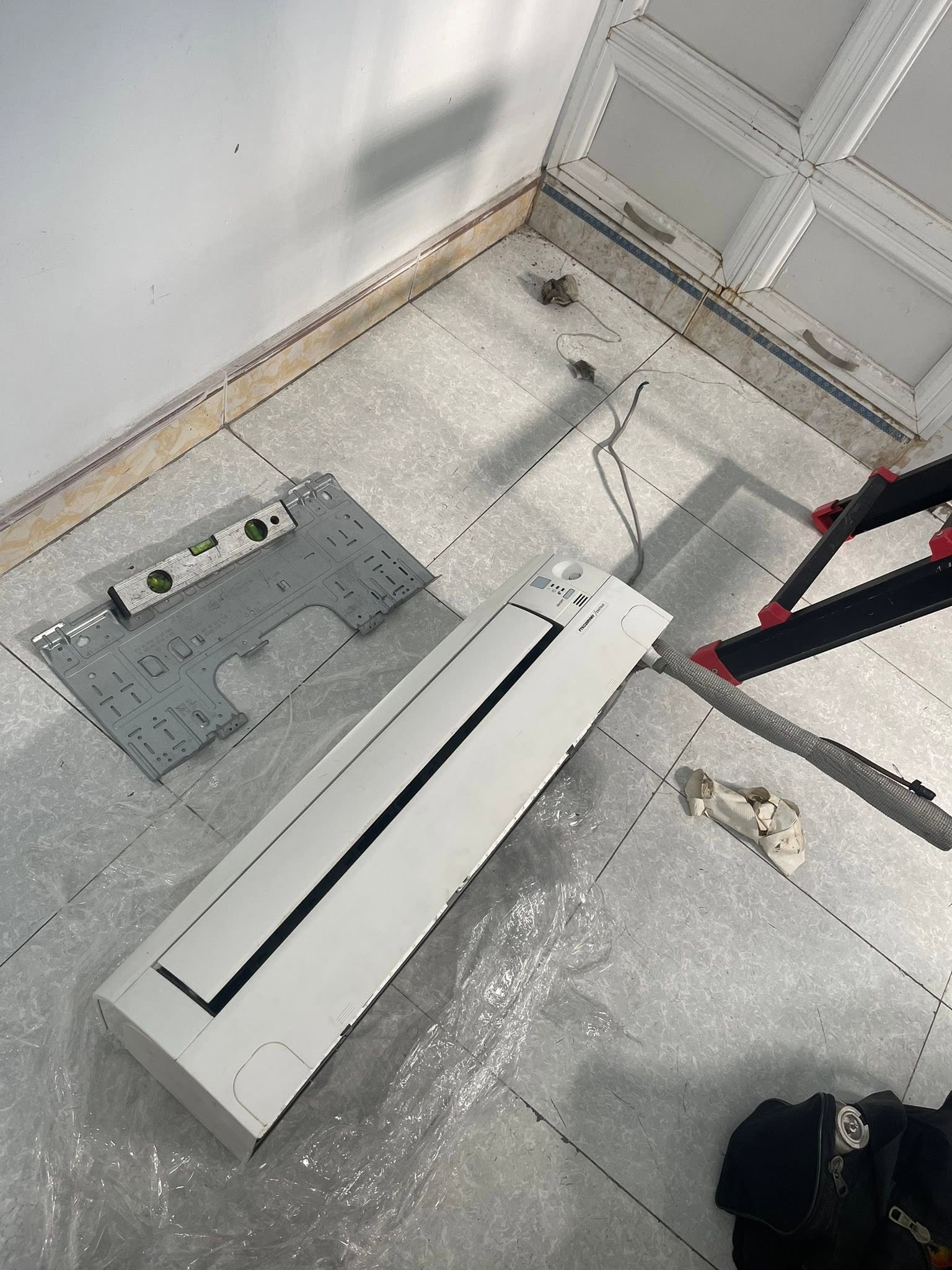 Dàn lạnh tháo rời cùng giá treo và thước thủy khi sửa máy lạnh kêu to