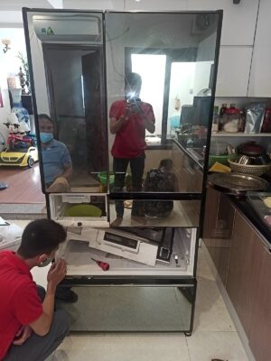 Thợ ngồi kiểm tra ngăn kéo tủ lạnh nhiều cánh mặt gương khi sửa tủ lạnh quận 1 tại nhà