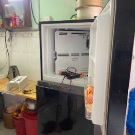 Ngăn đá tủ lạnh tháo nắp dàn lạnh, đồng hồ đo điện đặt bên trong khi sửa tủ lạnh Hóc Môn tại nhà