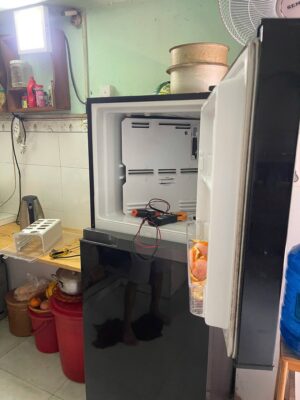 Ngăn đá tủ lạnh tháo nắp dàn lạnh, đồng hồ đo điện đặt bên trong khi sửa tủ lạnh Hóc Môn tại nhà