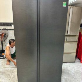 Thợ ngồi kiểm tra phía sau tủ lạnh side-by-side khi sửa tủ lạnh Củ Chi tại nhà