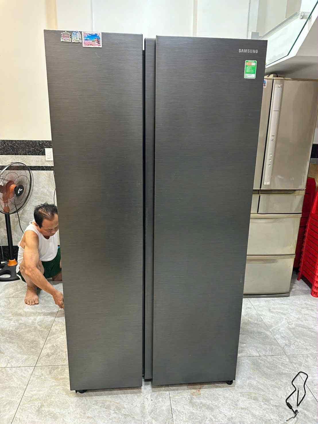 Thợ ngồi kiểm tra phía sau tủ lạnh side-by-side khi sửa tủ lạnh Củ Chi tại nhà