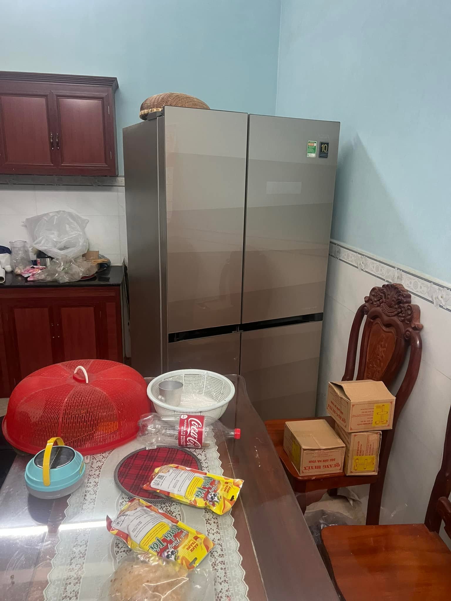 Tủ lạnh 4 cánh ánh kim kê sát góc tường trong phòng ăn, cạnh tủ bếp gỗ