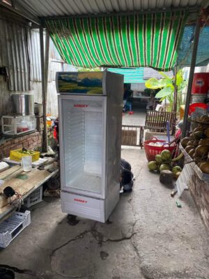 Thợ kiểm tra tủ mát tại tiệm tạp hoá khi sửa tủ mát Điện Máy Xanh đã hết bảo hành