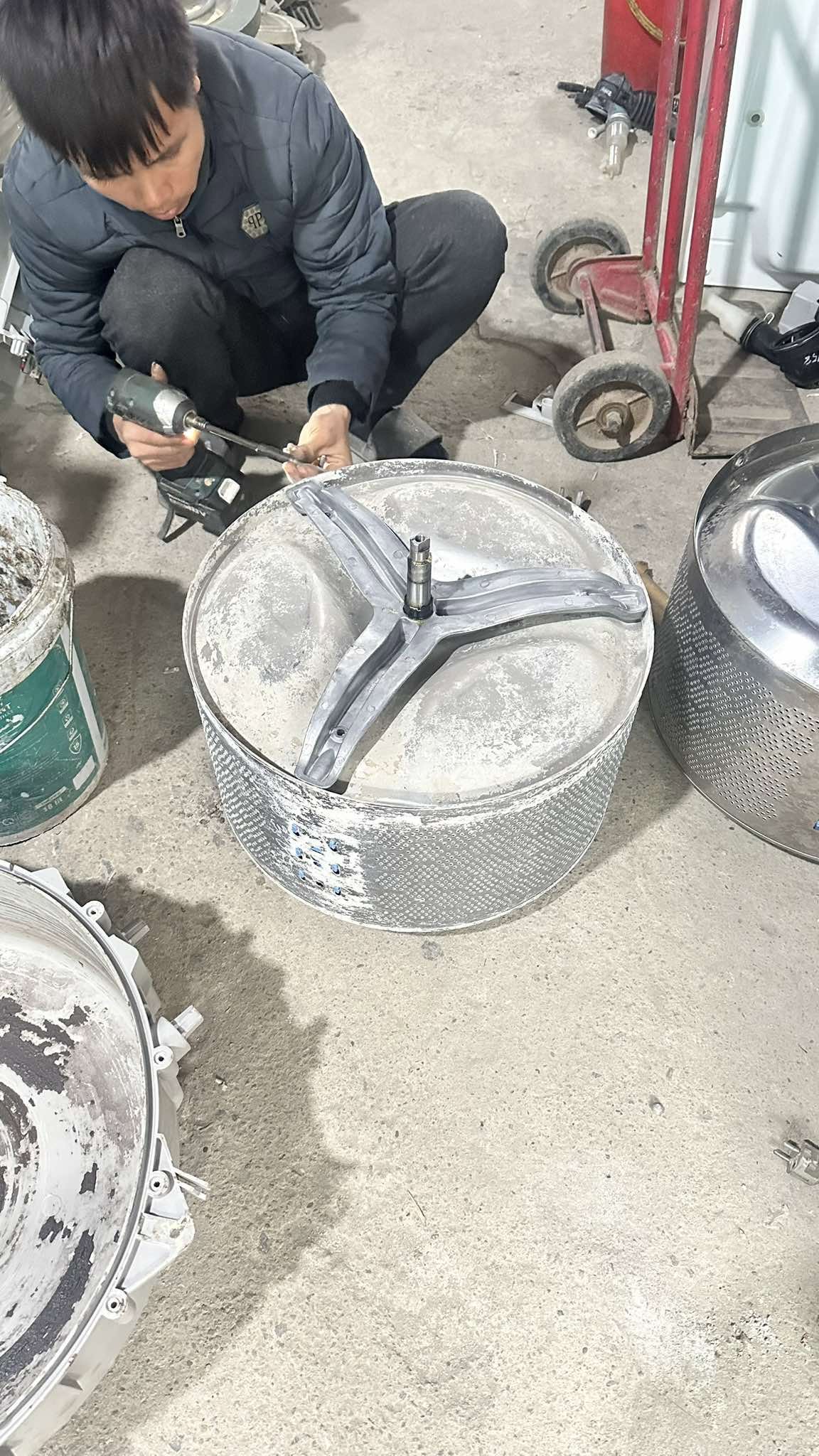 Thợ tháo mâm giặt khỏi lồng inox để thay vòng bi máy giặt kêu to khi vắt